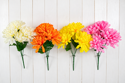 Four artificial ball mum chrysanthemum flower bushes in cream, orange, yellow and pink, each featuring five rounded flower heads with layered petals, green foliage and bundled stems.